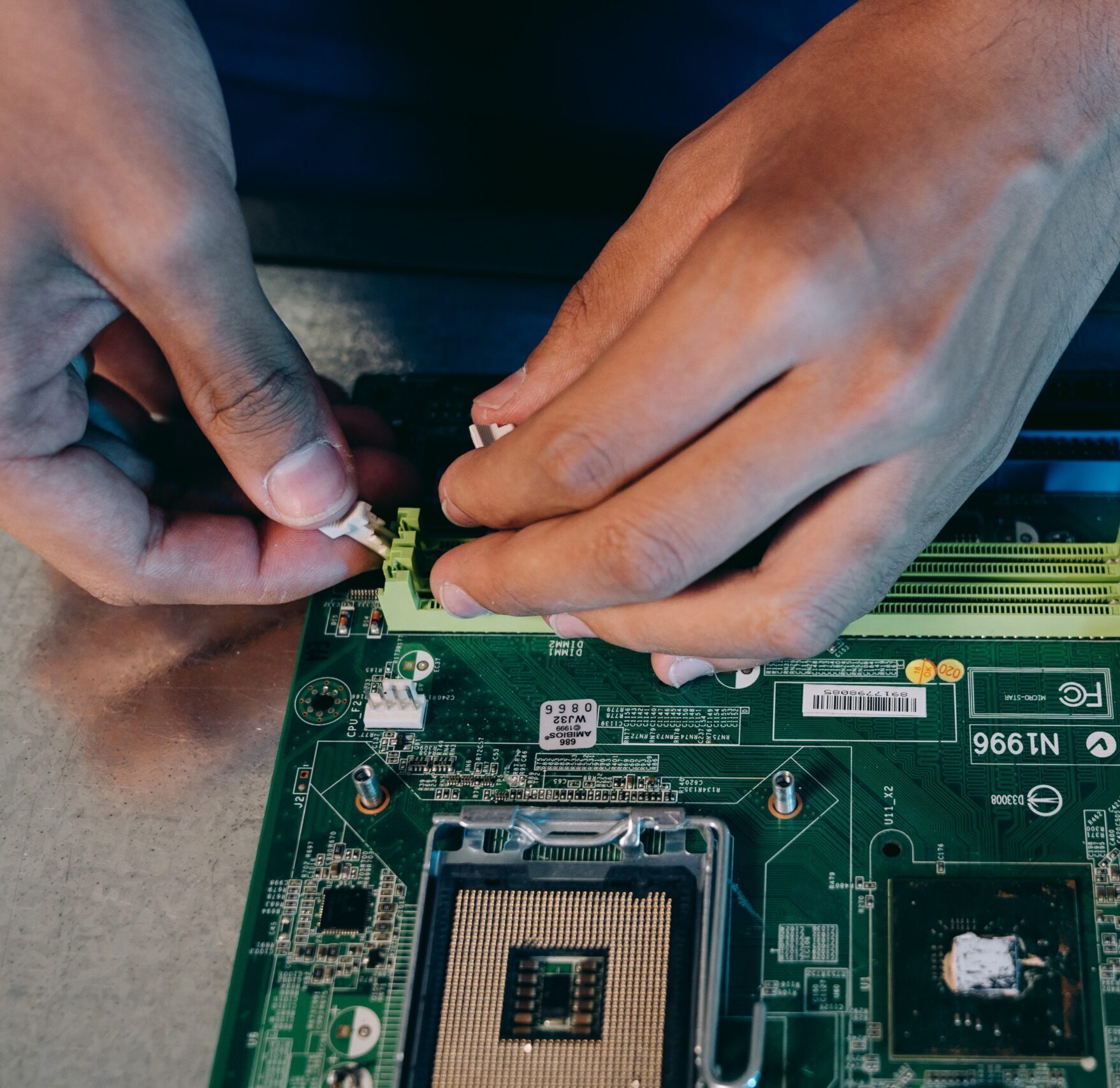 hands repairing a motherboard